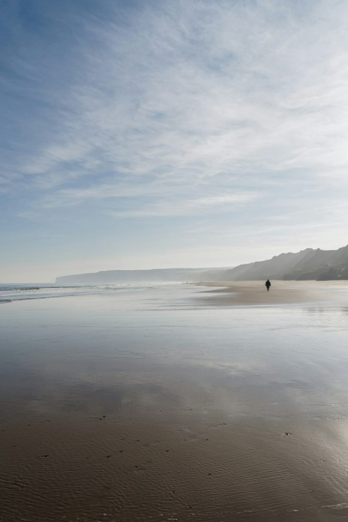 person standing on seashore during daytime